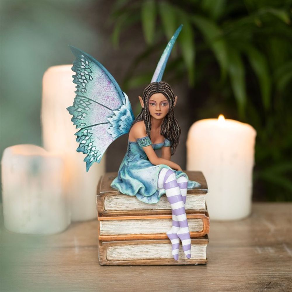 Book Fairy Figurine by Amy Brown. Based on the ‘Book Fairy’ series of watercolour paintings by fantasy artist Amy Brown, this high-quality collectible fairy figurine features painted accents that perfectly capture every magical detail of the original artwork. Intricately sculpted and cast in resin, this purple and teal fairy sits sweetly atop a small stack of books, making it a perfect display piece for lovers of fantastical creatures and magical realms. This figurine is officially licensed.